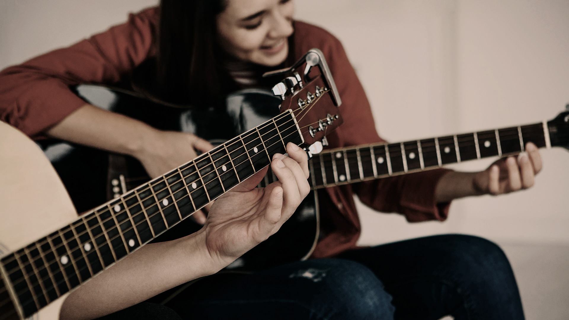 Photo of a silhouette of 2 dancers posing in front of a red curtain.